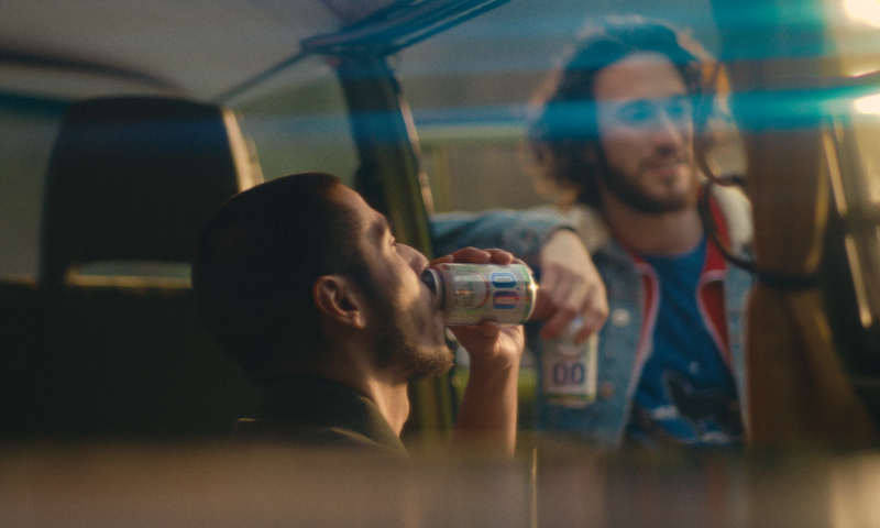 Man drinkt Grolsch 0.0% uit een blikje in een camper